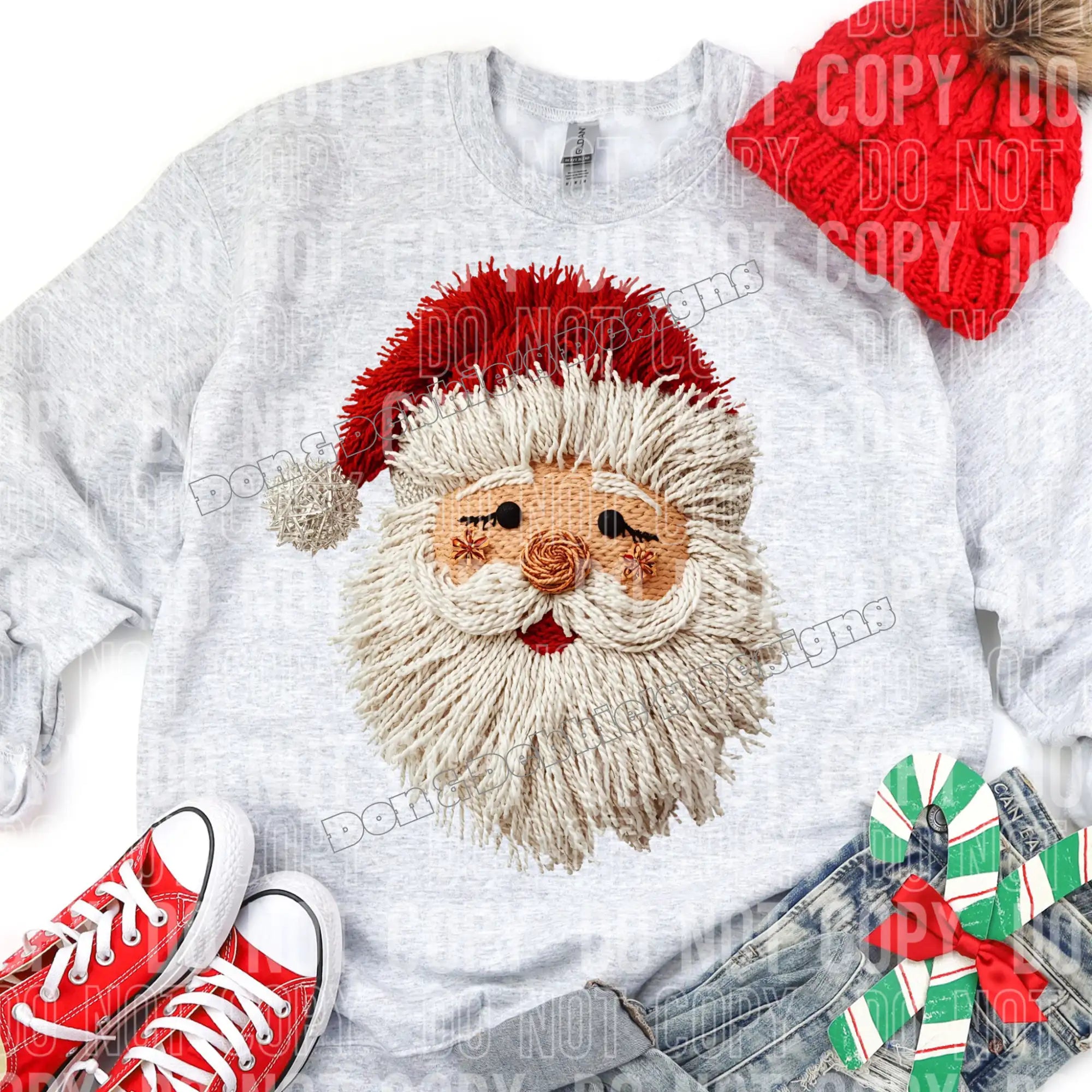 White sweatshirt with embroidered Santa Claus face design, paired with red sneakers and denim jeans on a white background.